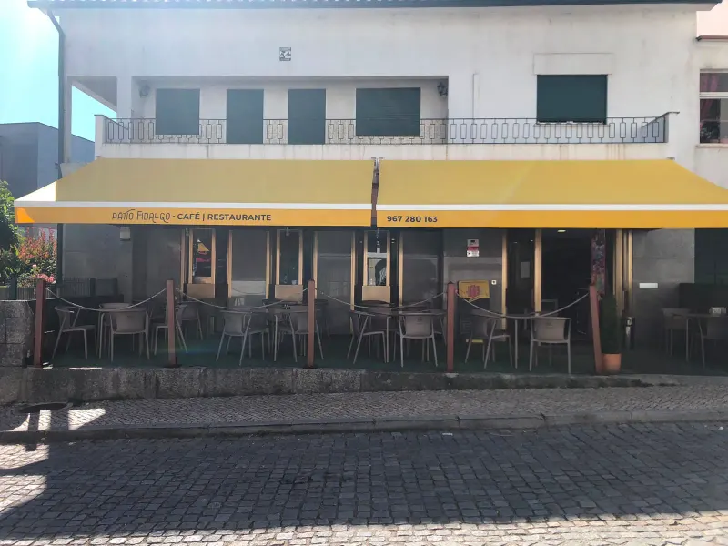Fachada do Pátio Fidalgo com o toldo amarelo e a esplanada